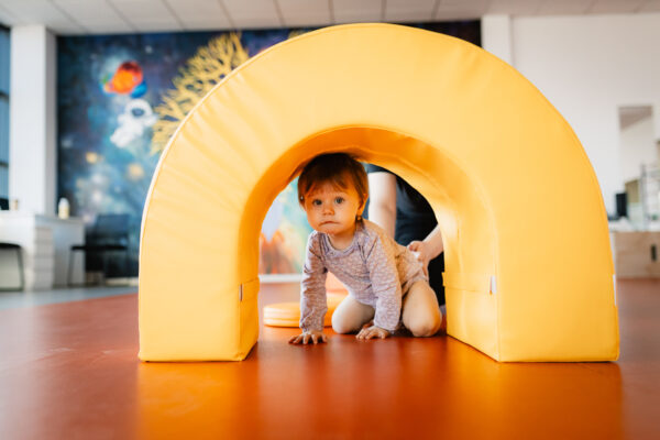 arra-medical-center-terapie-bobath Fetiță mică participă la o sesiune de kinetoterapie pediatrică, supravegheată de un specialist, într-un spațiu modern de recuperare pentru copii; imagine reprezentativă pentru servicii de kinetoterapie copii Iași, recuperare neuromotorie, exerciții de stimulare motorie, tratamente personalizate pentru afecțiuni ortopedice și neurologice, desfășurate într-o clinică medical center prietenoasă, adaptată complet nevoilor fiecărui copil